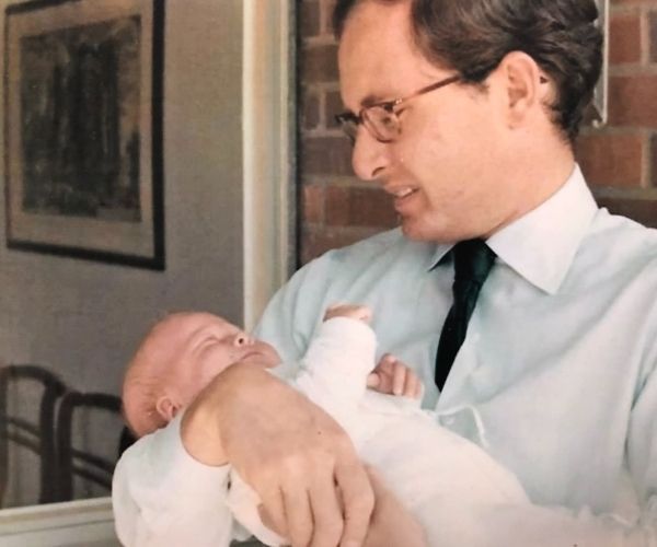 Miel de Botton as baby being held by her father.
